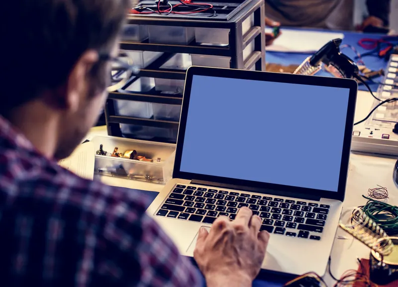 Technicien dépannant un ordinateur portable dans l’atelier