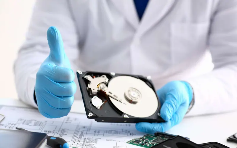 Technicien récupérant les données d’un disque dur ouvert